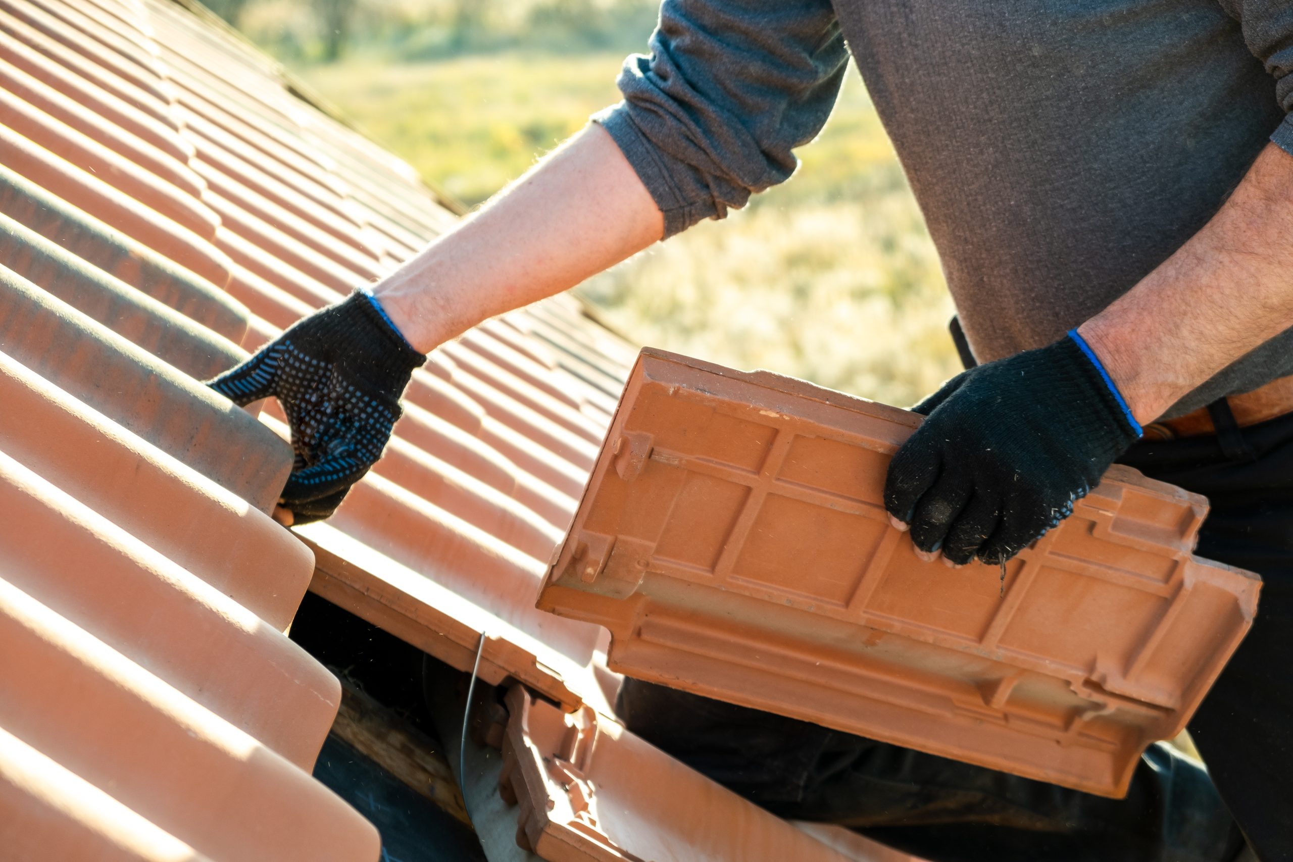 Worker Installing A Tile Roof On Home